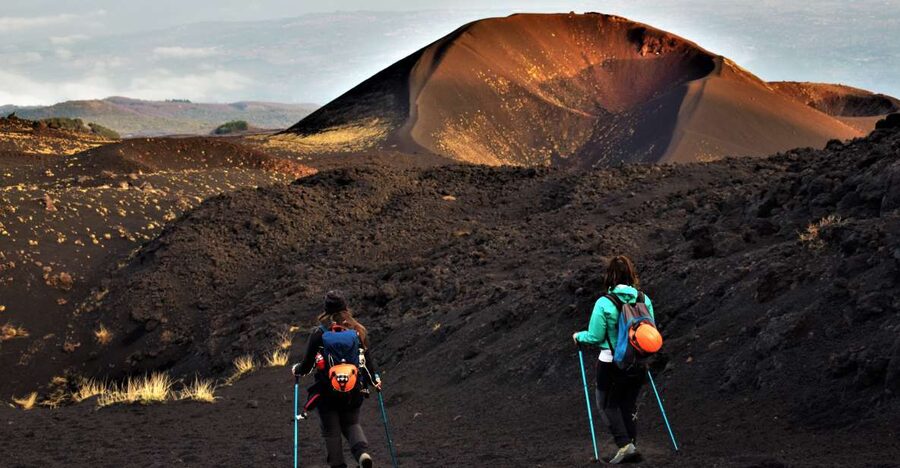 Catania: Etna Morning or Sunset Trek with Lava Tunnel & Gear - Walking through Etna’s black volcanic terrain