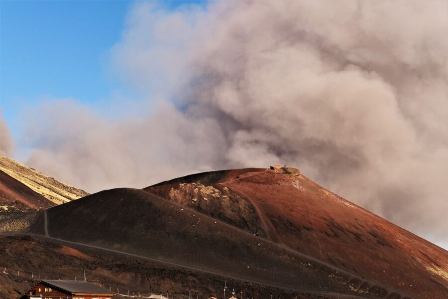 Catania: Etna Morning or Sunset Trek with Lava Tunnel & Gear - Entering a lava tube with helmet and flashlight
