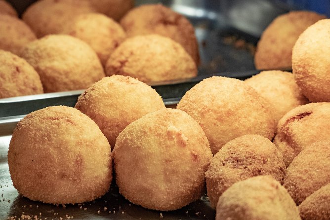 Small-group Street food tour in Messina - Choosing an arancino from a long list of fillings